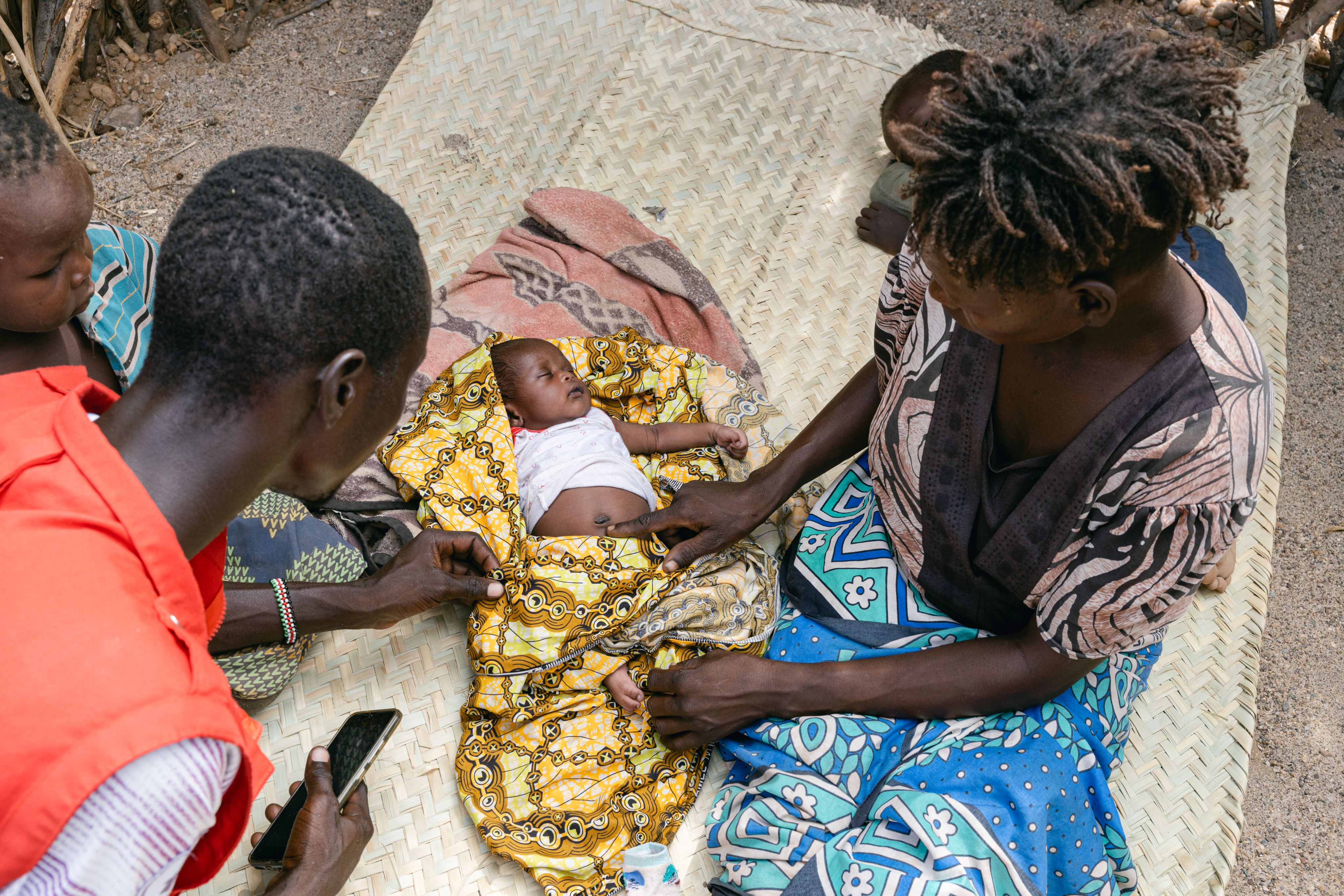 ommunity Health Promoter Charles completes a check up with baby Kevina at home