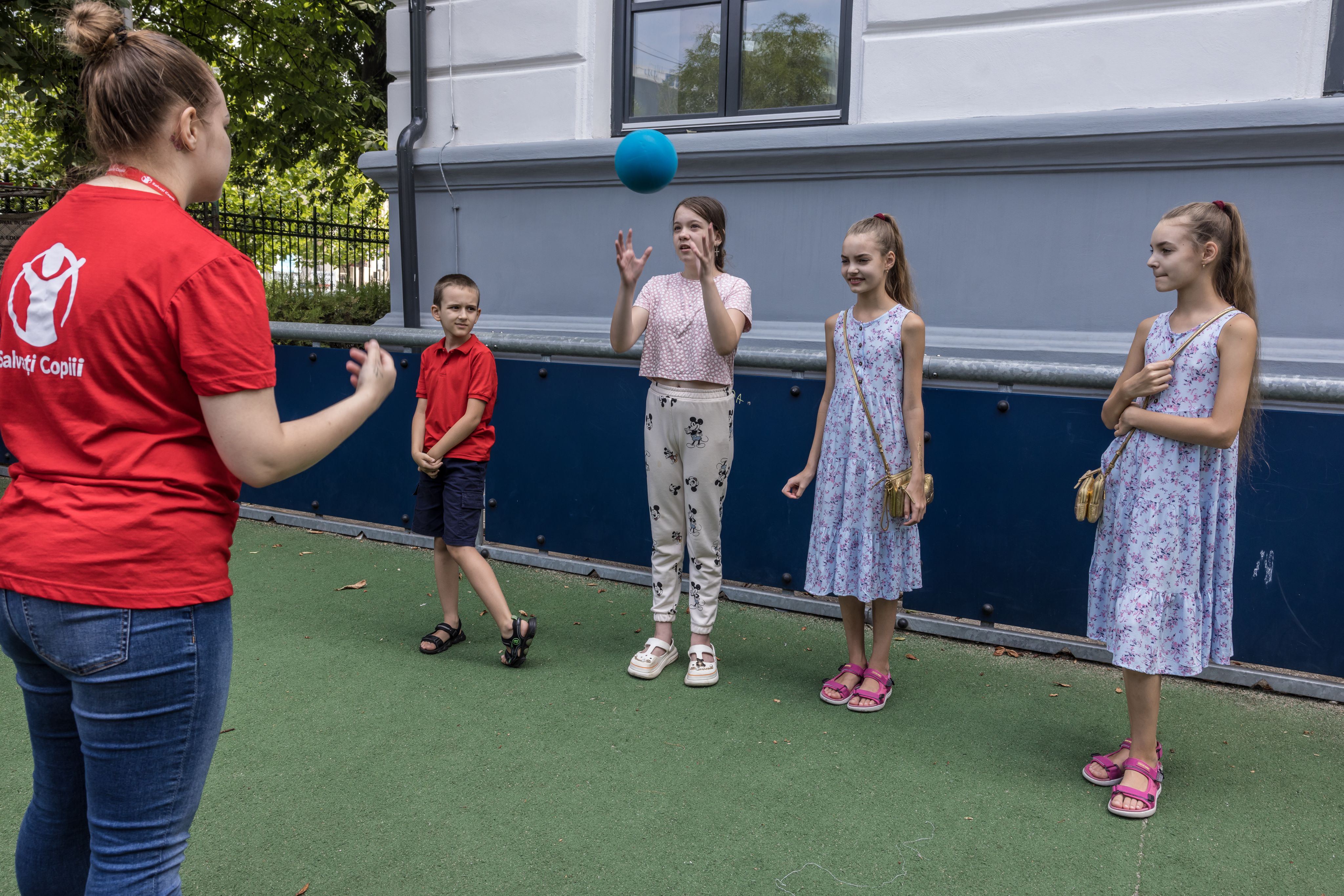 Mariia, Save the Children staff, Marko, eight, Alia 11, and twins, Polina and Nastia, 10, at Save the Children's hub, Bucharest, Romania