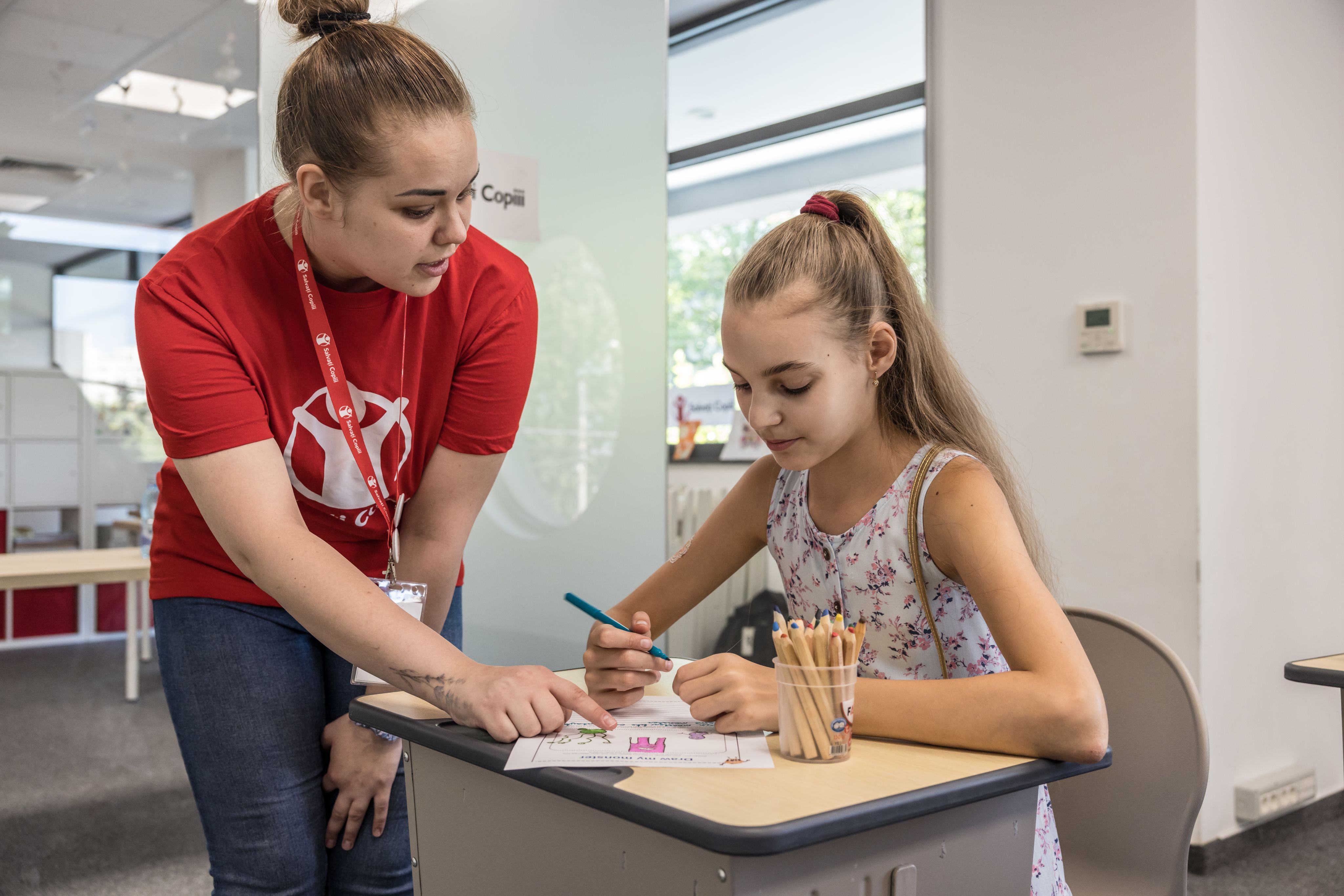Mariia, Save the Children staff, teaching Polina, 10, English at a hub for Ukrainian children, Bucharest, Romania