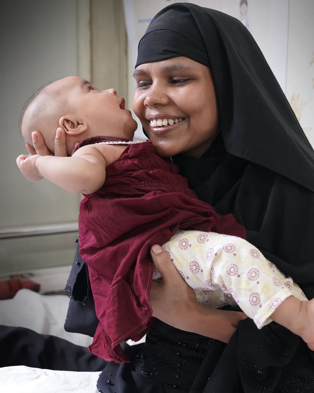 Majuma* 26 holds her daughter Maimuna* (4 months) during a health centre visit, Bangladesh