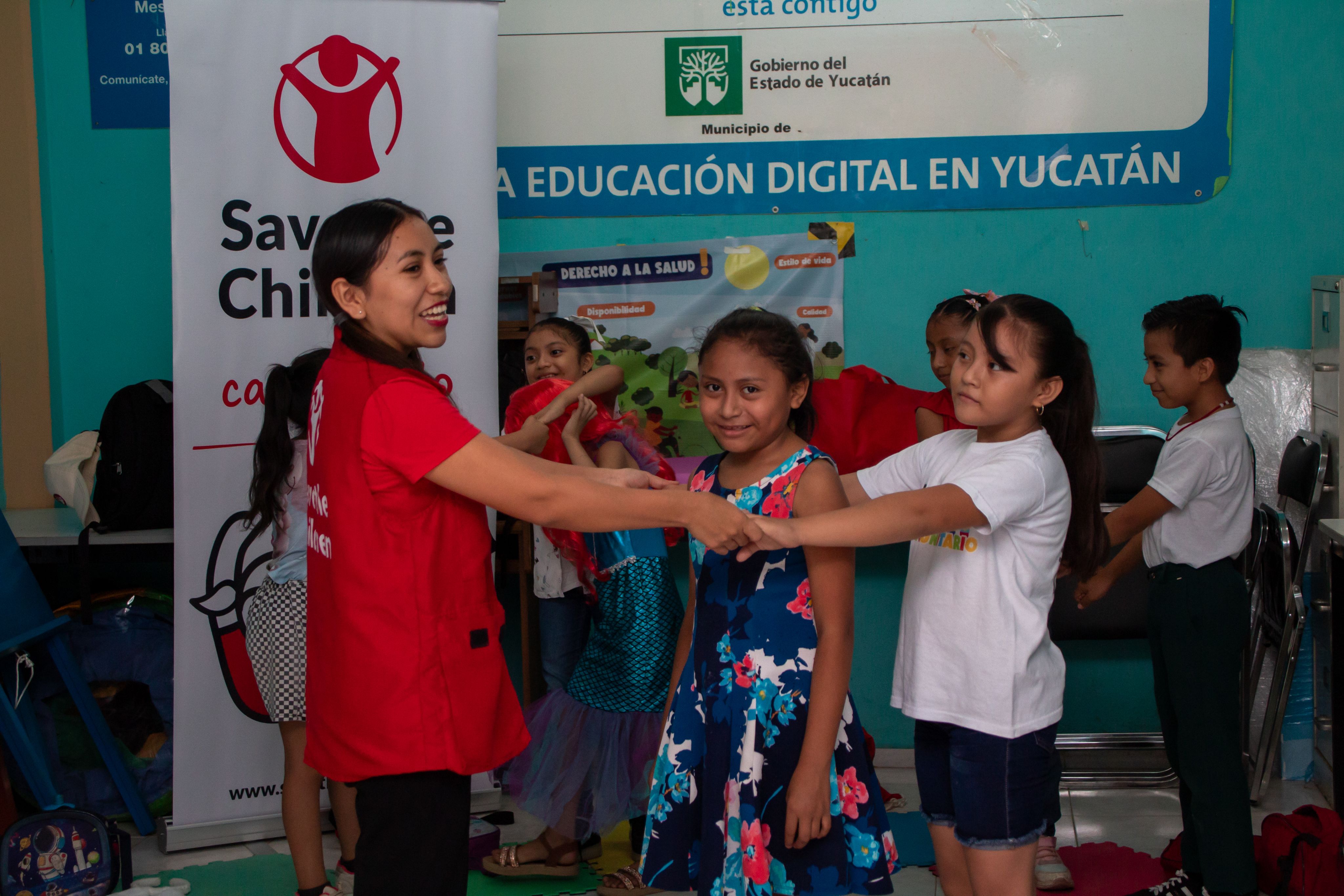 Camila, 8, and Valeria, 8, with Hilda, health promoter, playing the rabbit game during the community club session