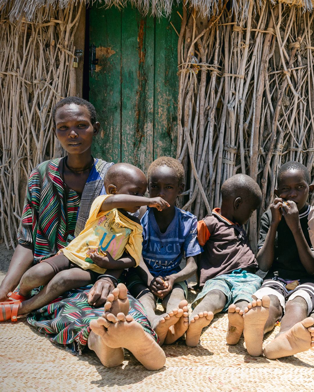 Ng'ikito, 34, Ingolan, 36, and their children in front of their home