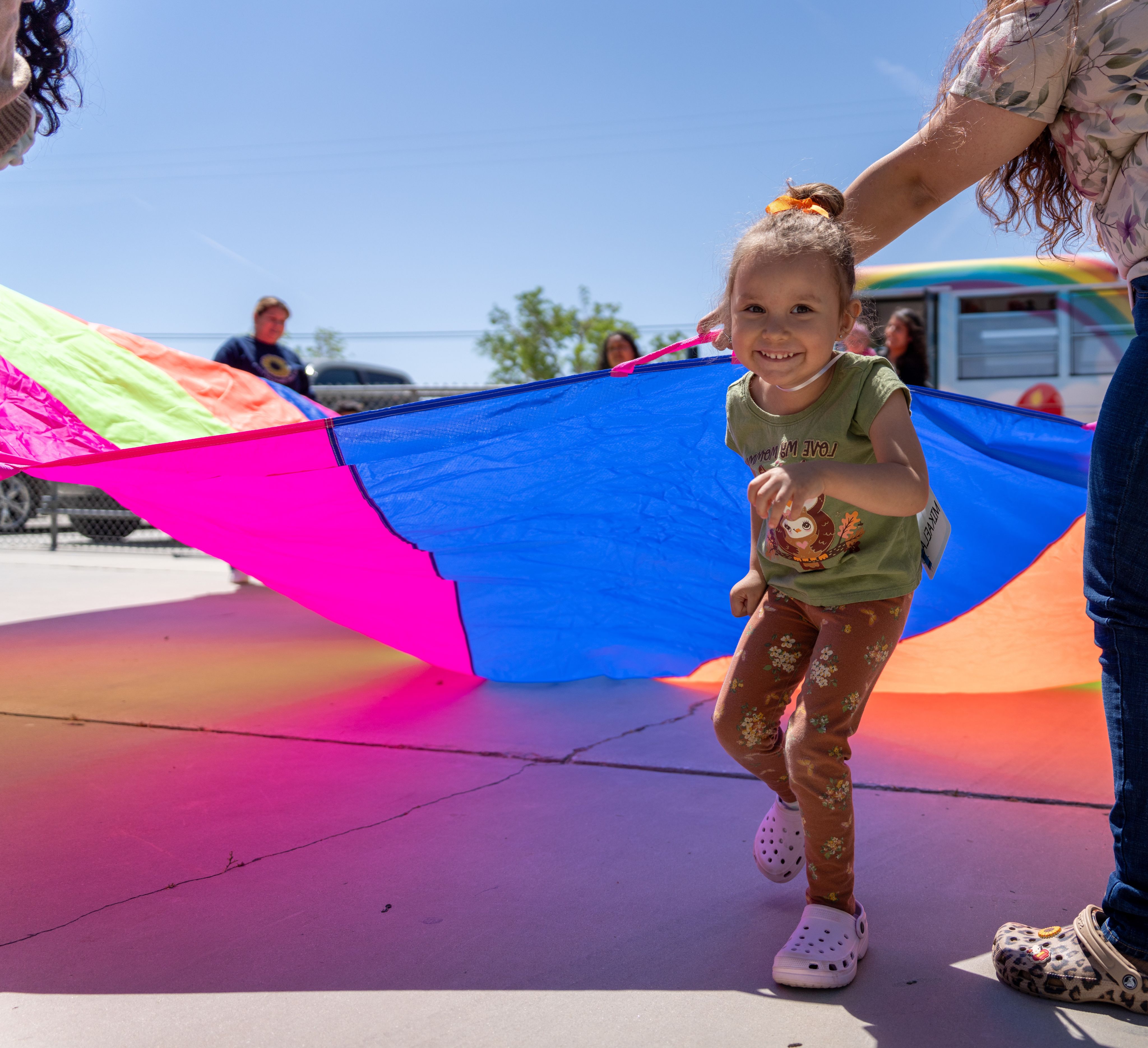 Young girl playing with a colorful parachute