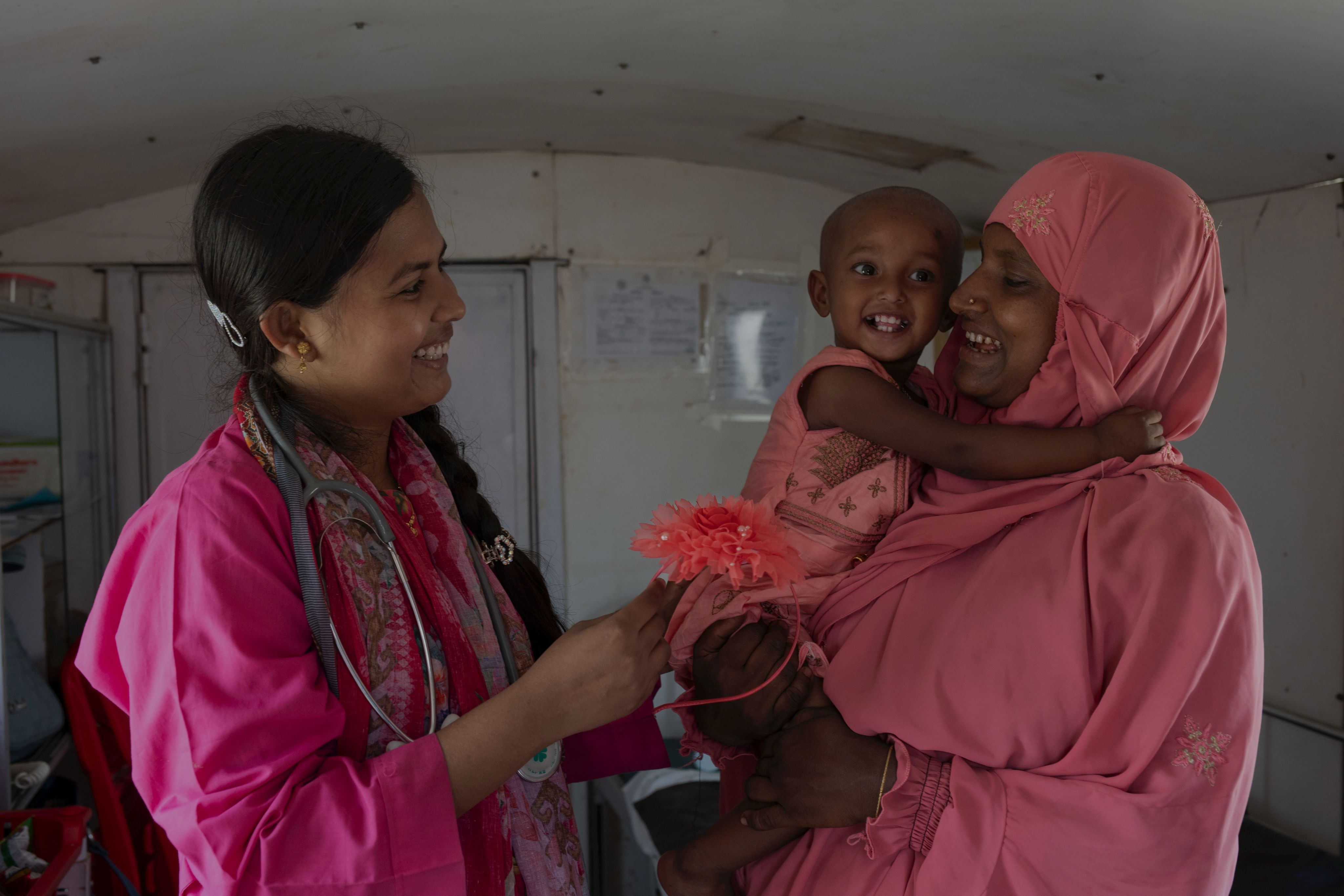 Smiling mom and baby with health worker