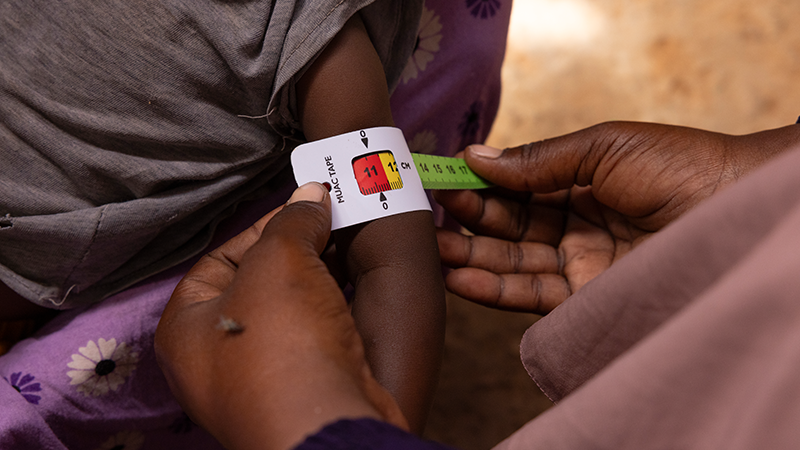 Close-up of a child's arm being measured for malnutrition