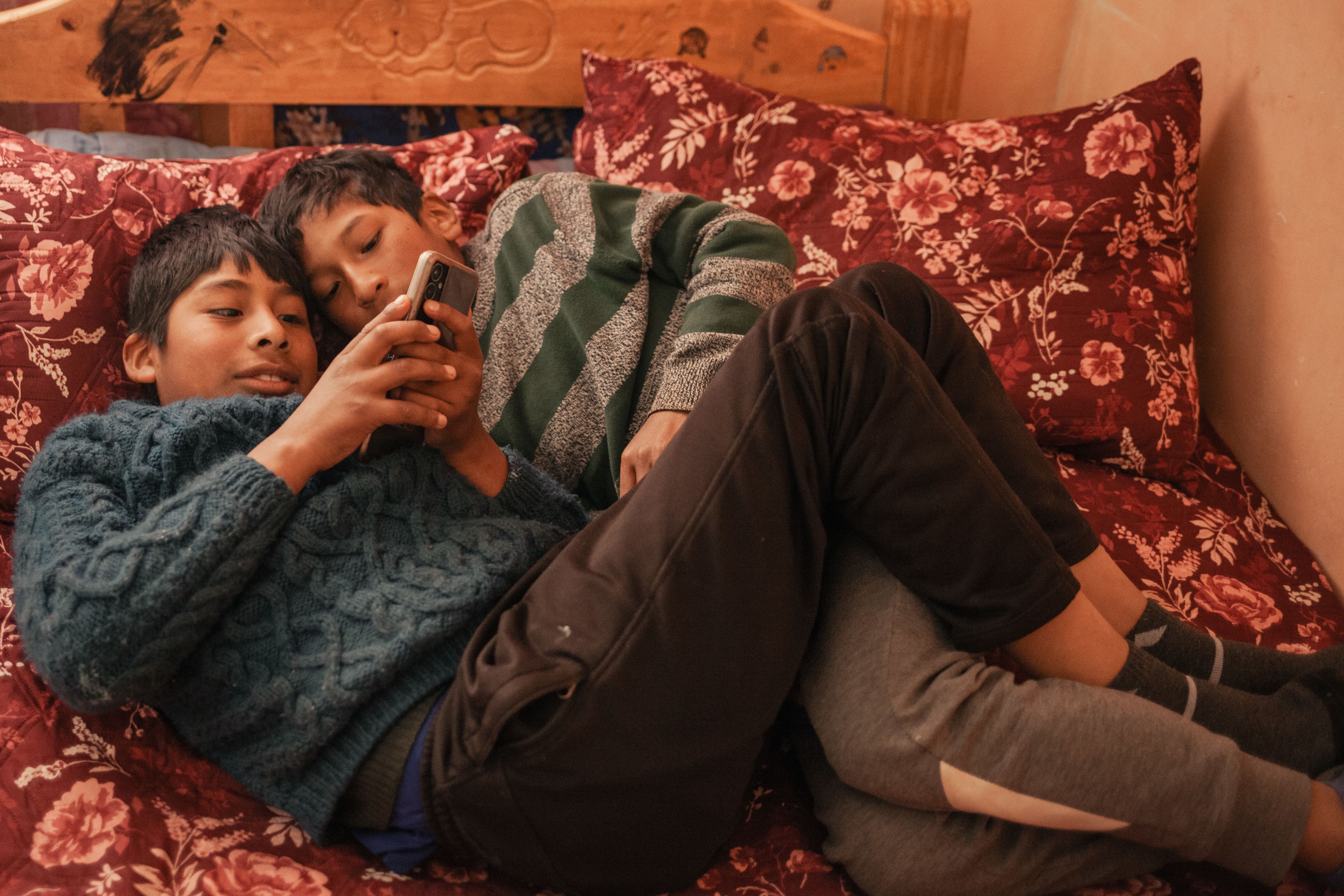 Two young boys looking at an iphone